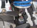 1996 Ford Bronco - Close-up view of a vehicle's front suspension system, highlighting a blue coilover shock absorber and associated mounting hardware.