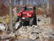 1991 Ford Bronco - A red Jeep Wrangler navigates a challenging rocky trail during an off-road excursion.