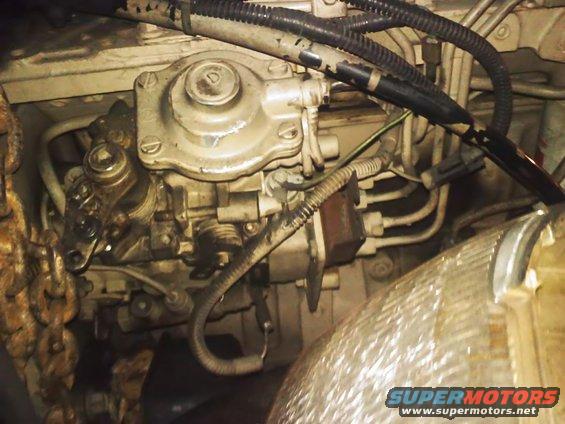 Close-up of an engine fuel injection pump with hoses and wiring