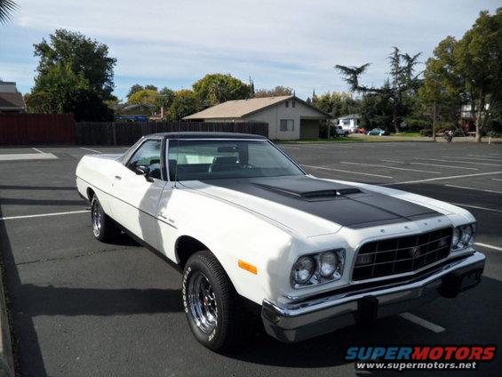 White 1973 Ford Ranchero with black hood stripe and black vinyl top parked in a lot