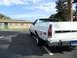 1973 Ford Ranchero - Rear view of a white 1973 Ford Ranchero pickup truck parked in a lot under a blue sky.