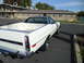 1973 Ford Ranchero - A white 1973 Ford Ranchero with a black vinyl top is parked outside a building.