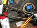 1994 Ford Escort - Close-up view of suspension components on a remote control car, including an orange coilover shock and a blue servo motor.