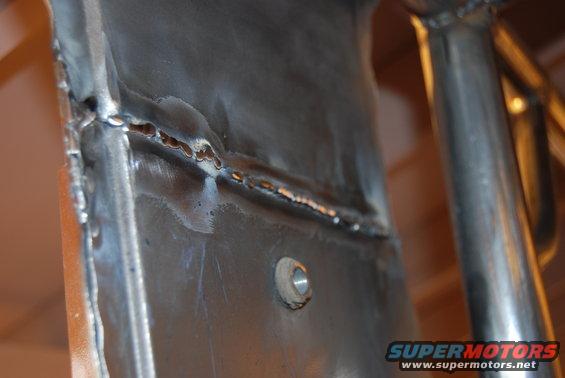 Close-up of welded metal frame with visible seam and bolt hole