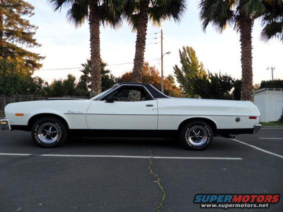 Side view of a white 1973 Ford Ranchero parked in a lot with palm trees