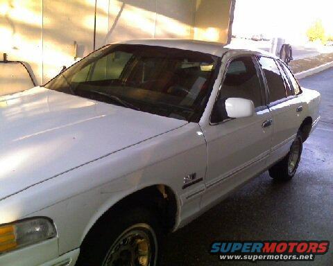White 1995 Ford Crown Victoria, front 3/4 view, showing driver's side fender, door, and rear quarter panel