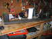1984 Ford Bronco - A workbench is cluttered with tools, supplies, and a metal fabrication project in progress.
