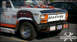 1984 Ford Bronco - This heavily customized pickup truck features a unique shark teeth grille and various decorative elements on its bumper.