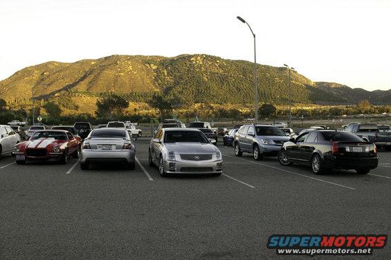 Silver 2006 Cadillac STS parked in a lot with a red Camaro and black Cadillac CTS