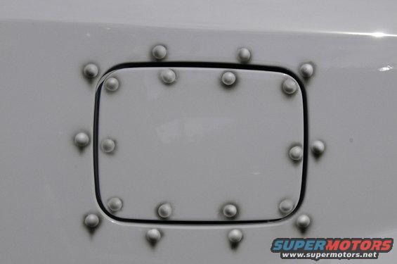 Gray fuel door with faux rivets on a vehicle