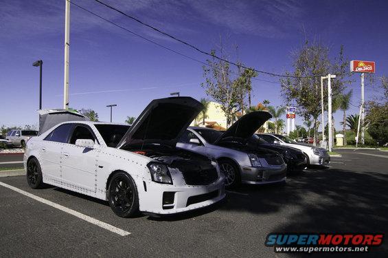 White 2006 Cadillac STS and other Cadillacs parked with hoods open