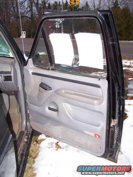 Interior door panel of a vehicle with white paper taped to the window