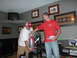 1992 Ford Mustang - Two men are in a room, one holding a fire extinguisher, with trophies and framed pictures visible.