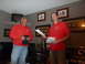1992 Ford Mustang - Two men stand in a room, one holding papers and the other a black cloth, with framed artwork on the walls.