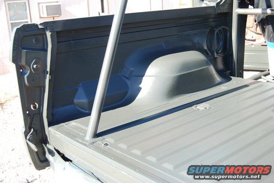 Truck bed interior with roll cage bars. Supermotors.net logo visible