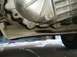 1986 Ford F-150 - Undercarriage view of a vehicle's transmission housing, showing a drain plug and signs of fluid leakage.