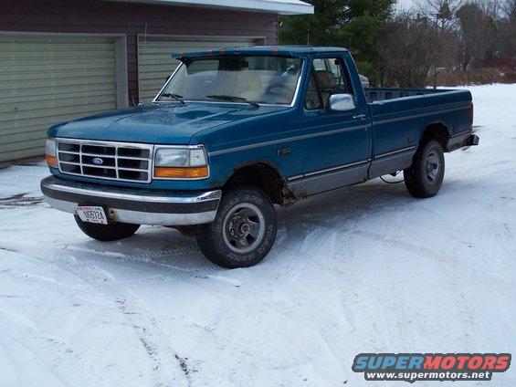 Blue 1994 Ford F-150 pickup truck parked in snow, front quarter view