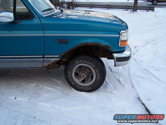 Teal 1994 Ford F-150 front fender and wheel with rust