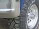 1986 Ford F-150 - Close-up of a chrome bumper and a tire with 'WRANGLER' branding visible.
