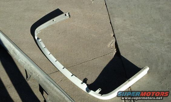 White bumper trim piece on concrete