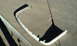 2003 Acura TL - A white bumper trim piece lies on a concrete surface, casting a shadow.