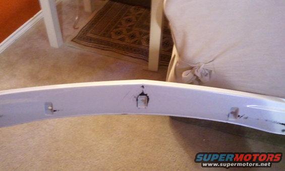 White car bumper with mounting holes and some scratches
