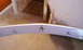 2003 Acura TL - Close-up of a white car bumper part, showing mounting points and damage.