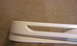 2003 Acura TL - Close-up of a white car bumper part with a horizontal opening, against a textured background.
