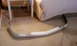 2003 Acura TL - A white front bumper part rests on a carpeted floor next to a bed and table.