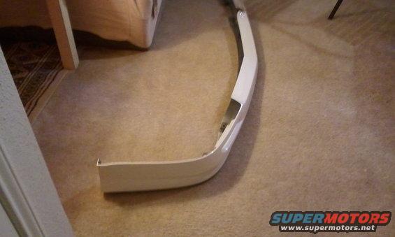 White car bumper part lying on carpeted floor