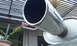 2003 Acura TL - Exhaust pipe and muffler shown with a background of plants and a pergola. Supermotors.net logo is visible.