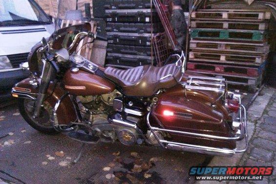 Brown motorcycle parked outdoors, side view
