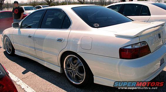 White 2003 Acura TL sedan with custom wheels and body kit parked in a lot
