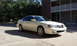 2003 Acura TL - A white 2003 Acura TL sedan is parked in a lot with a building in the background.