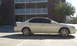 2003 Acura TL - Side view of a white sedan with tinted windows and alloy wheels parked in a lot.