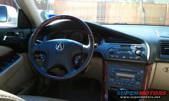 Interior shot of a 2003 Acura TL showing the steering wheel, dashboard, and center console