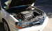 2003 Acura TL - The engine bay of a white Acura is visible with the hood open, revealing the engine components.