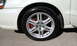 2003 Acura TL - Front wheel and fender of a white 2003 Acura TL with a silver 5-spoke alloy wheel.