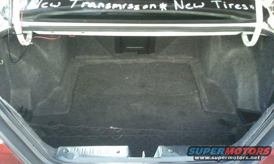 Car trunk interior with handwritten text on the lid saying 'New Transmission * New Tires'