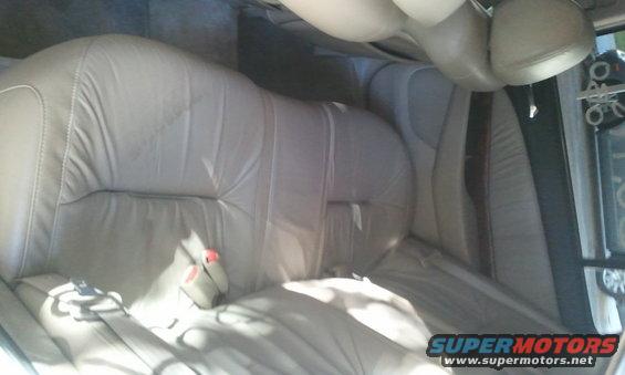 Interior view of tan leather seats and seatbelts