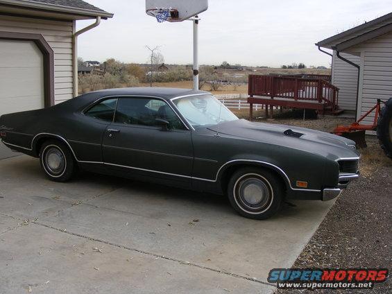 1971 Mercury Cyclone parked in driveway, dark green paint, hood scoop