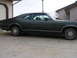 1971 Mercury Cyclone - A dark coupe with a distinctive body style is parked on a concrete driveway next to a garage.