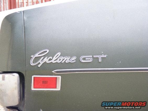 Green car's rear quarter panel with a red taillight and a chrome 'Cyclone GT' emblem