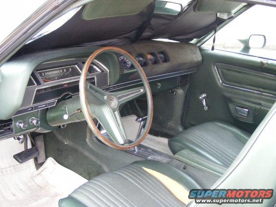Green 1971 Mercury Cyclone interior with wood-rimmed steering wheel, dashboard, and seats