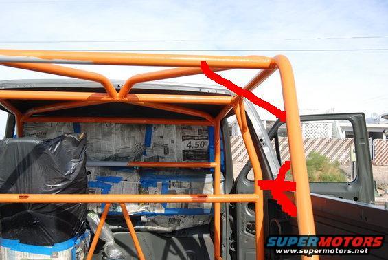 Orange roll cage being installed inside a vehicle, with newspaper covering the interior panels