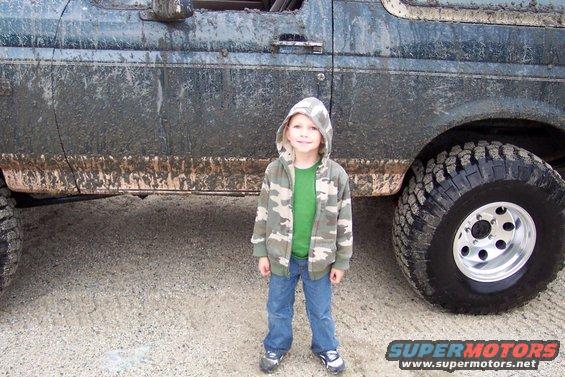kid in camo jacket by dirty SUV