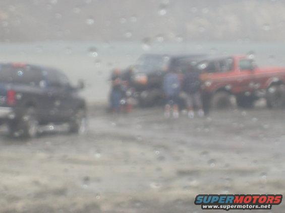 Red pickup truck and dark SUV in a blurry outdoor scene