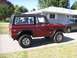 1970 Ford Bronco - A red 1970 Ford Bronco is parked in a driveway next to another vehicle, a black hardtop and custom wheels.