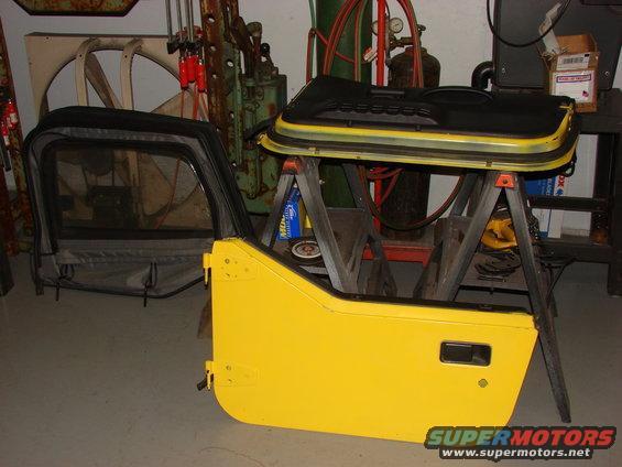 Yellow Jeep doors and soft top disassembled