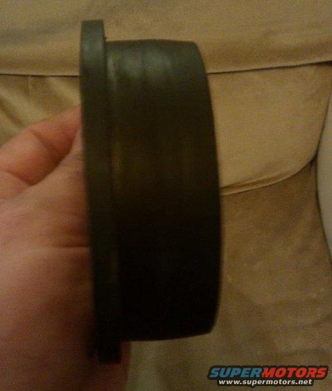 Dark circular car part held by hand